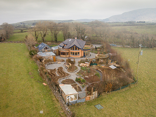 view of mud and wood house garden